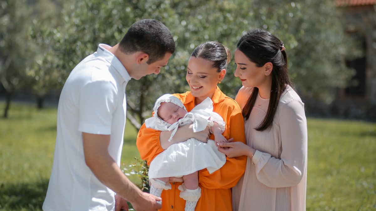 A joyful family moment with a newborn baby outdoors, capturing love and togetherness.